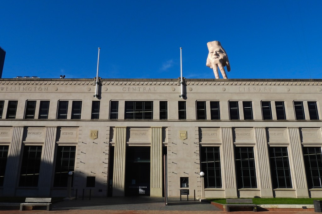 A 16-foot-tall handmade sculpture called Quasi tiptoes atop an art gallery roof in Wellington, New Zealand